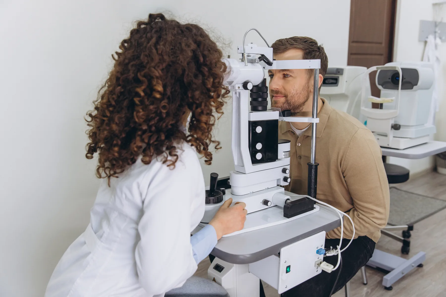 Eye care professional examining a patient with a slit lamp