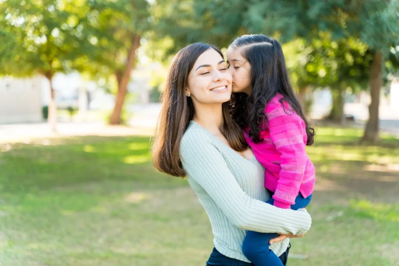 Mother and daughter sharing a moment outdoors