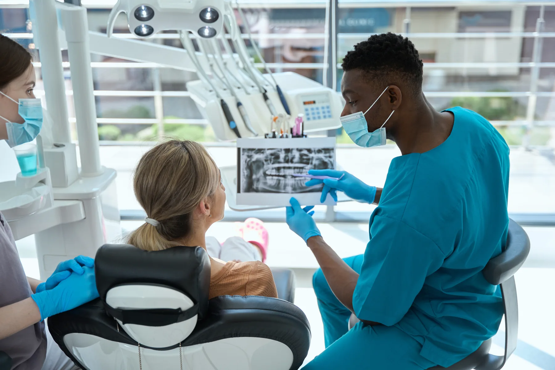 Dental professional showing a patient dental X-rays on a monitor